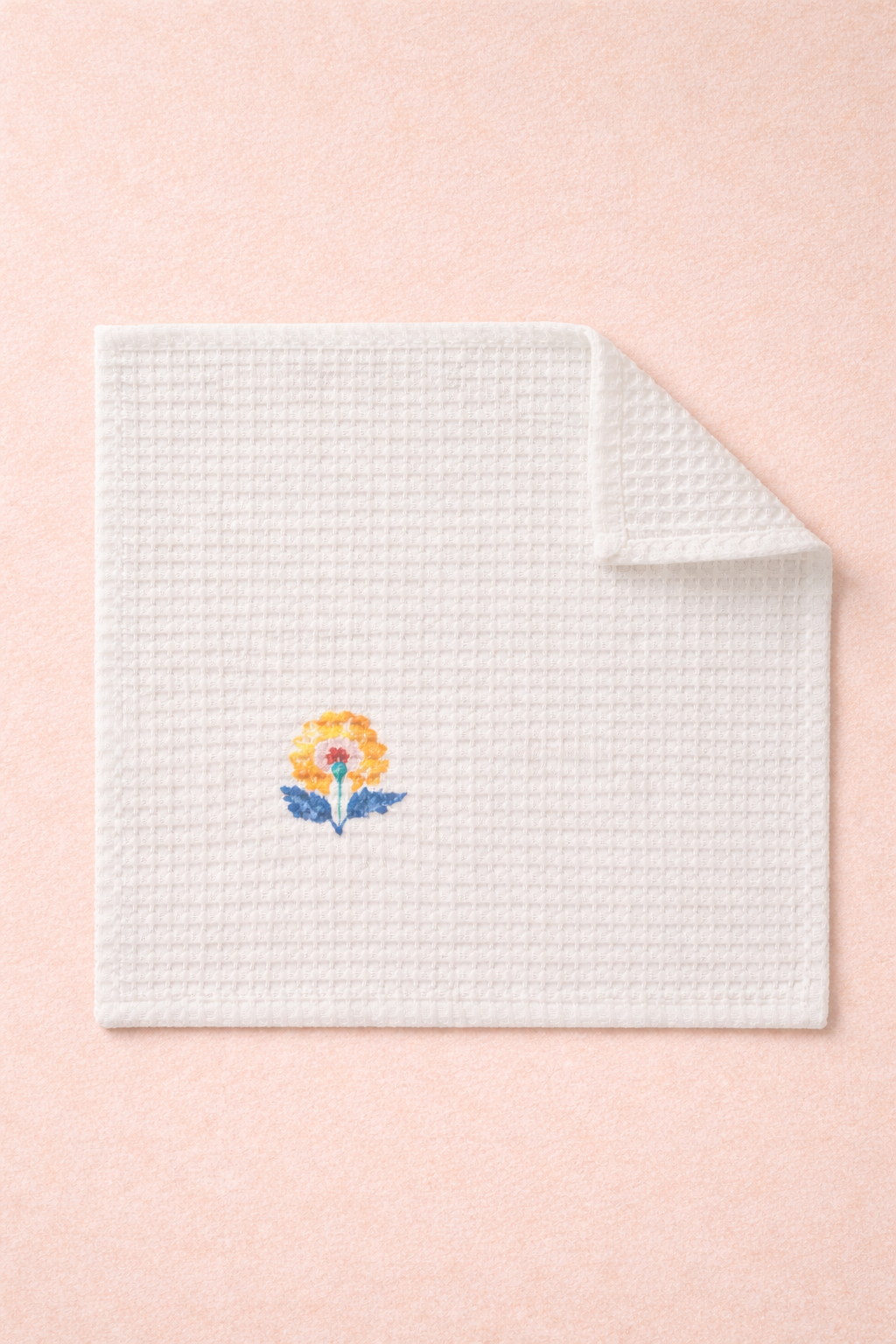 ivory cotton waffle face towels with hand block-printed floral motifs in blue, mustard, and coral