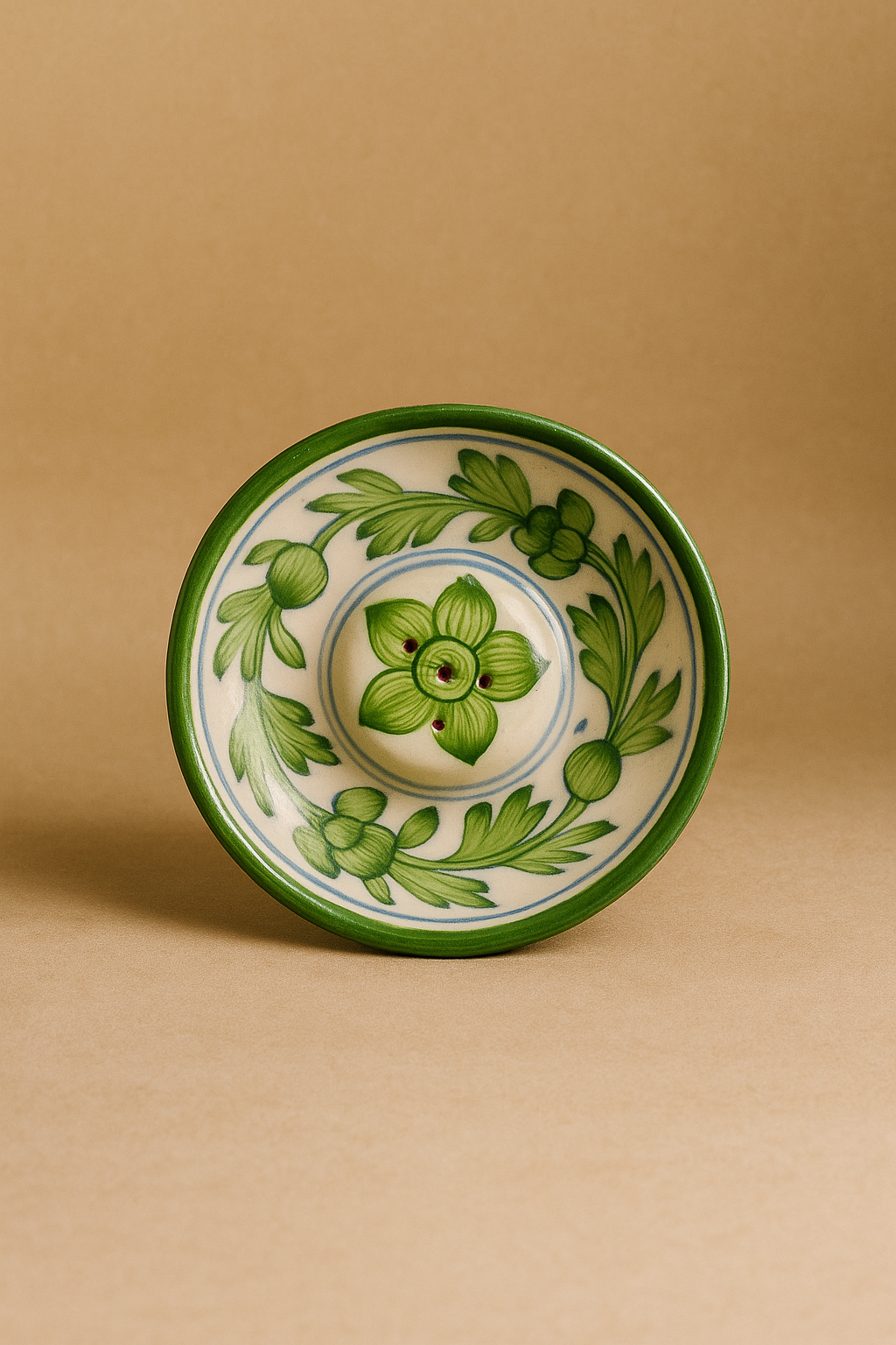 Ceramic incense dish with green leaf patterns on a beige background